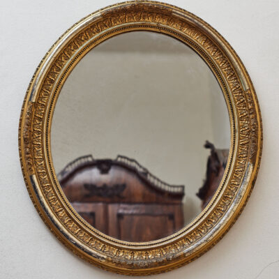 Oval gilded mirror with a richly decorated frame, 19. century