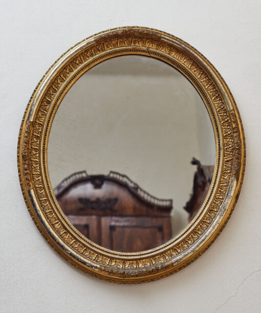 Oval gilded mirror with a richly decorated frame, 19. century